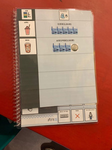 A spiral bound communication book with images of options at the coffee shop.