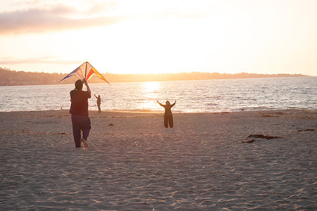 Image of people flying a kite at the beach in Marina, CA